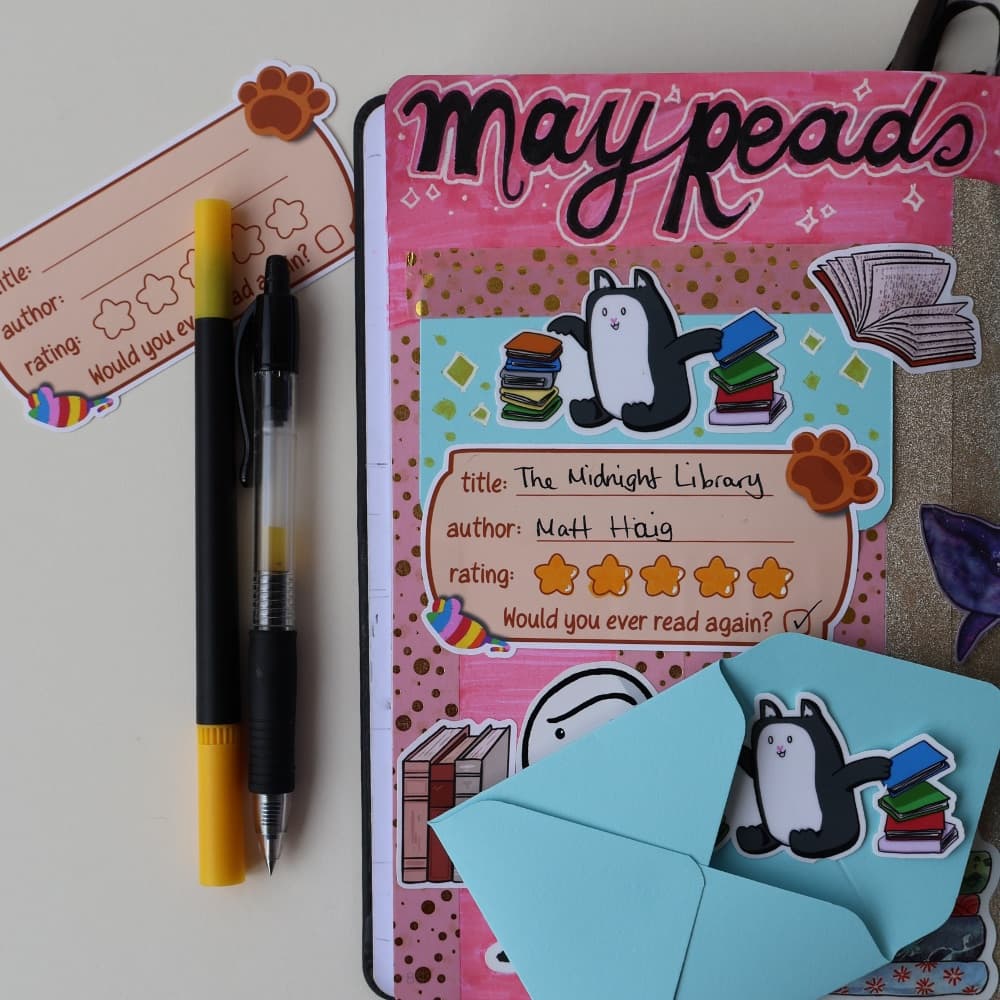 A reading log spread rating The Midnight Library, decorated with Pumpkin and Tootsie stickers