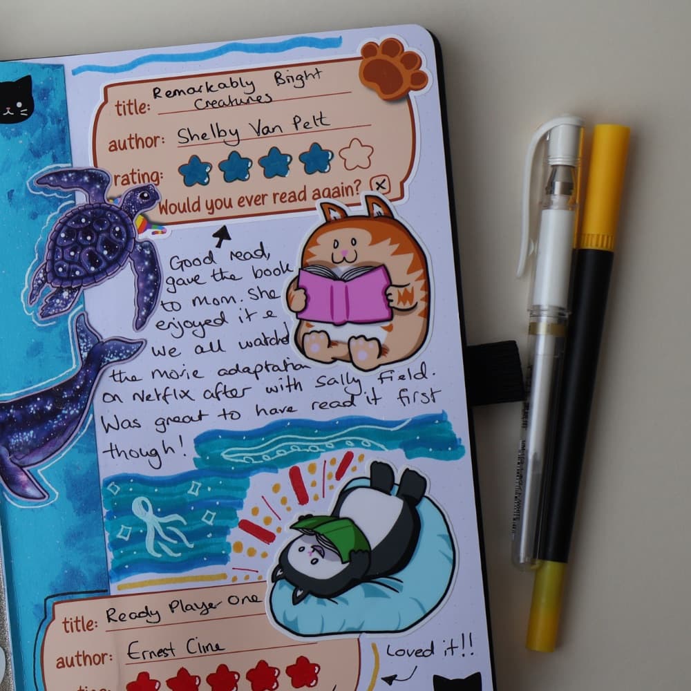 A journal page rating two finished books, with reading-themed stickers and a handwritten note